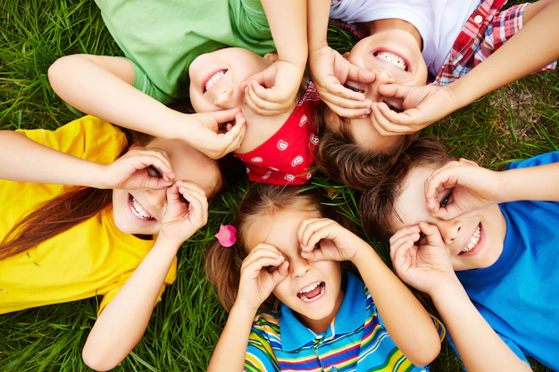 Enfants allongés et souriants réalisant un exercice ludique de sophrologie à Ventabren