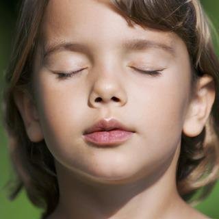 Enfant les yeux fermés pendant un exercice de relaxation en sophrologie à Ventabren